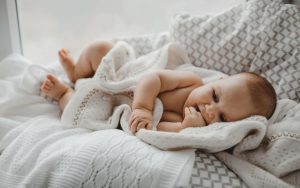 Beba lezi na krevetu zavijena u cebence