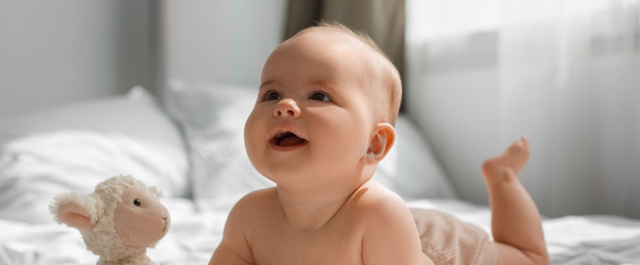 Beba lezi na krevetu i smeje se