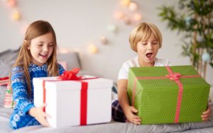 Decak i devojcica otvaraju novogodisnje poklone